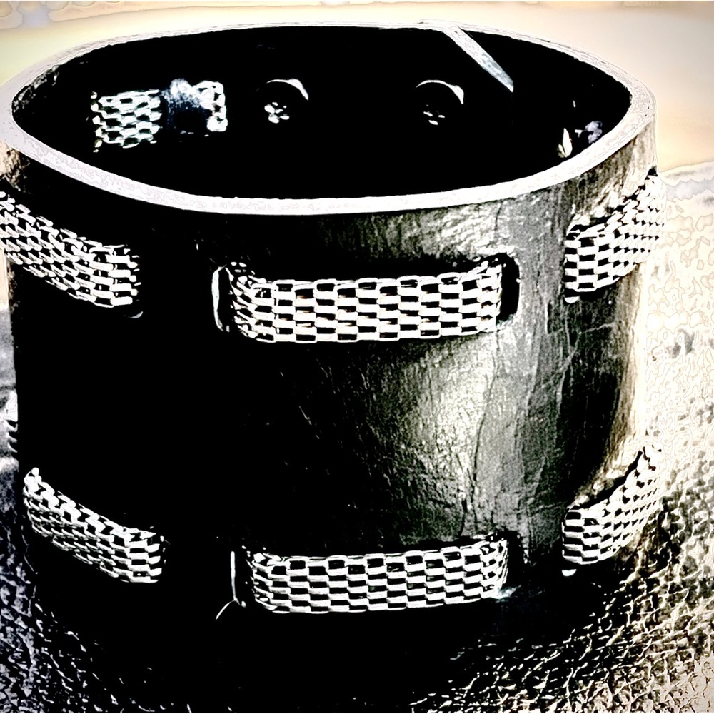 Leather bracelet cuff with embellished silver metal surrounding the cuff.